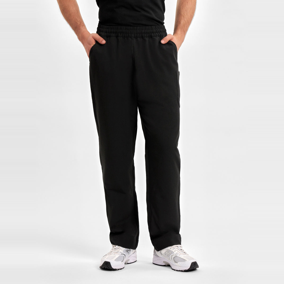 Inaura Pulse Unisex Straight Leg Scrub Pant CL542UL in Black, worn by model, view 2