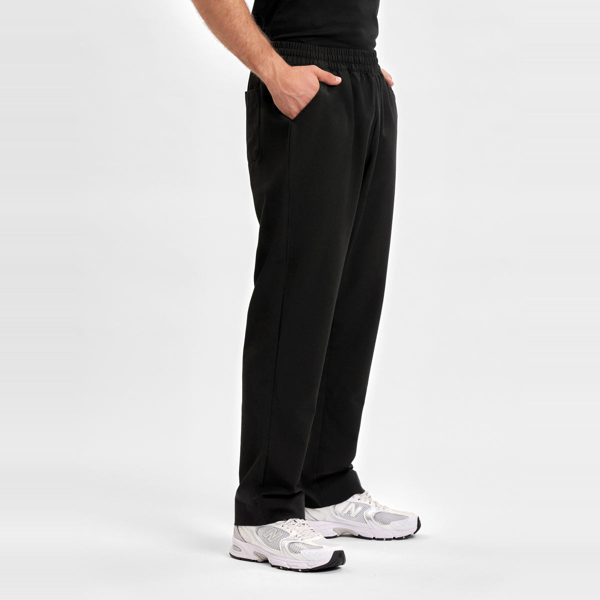 Inaura Pulse Unisex Straight Leg Scrub Pant CL542UL in Black, worn by model, view 3