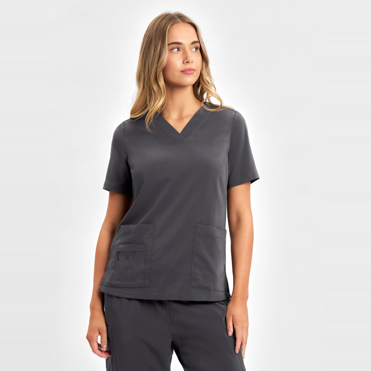 Inaura Avery Womens V-Neck Scrub Top CST941LS in Charcoal, worn by model