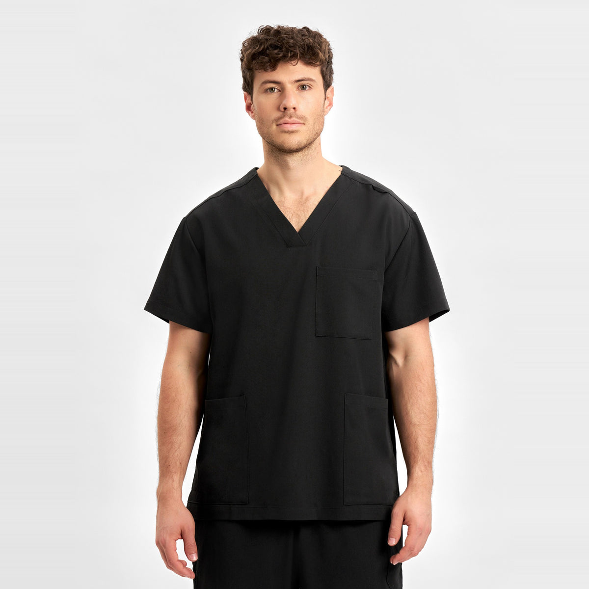 Inaura Pulse Unisex V-Neck Scrub Top CU544US in Black, worn by model