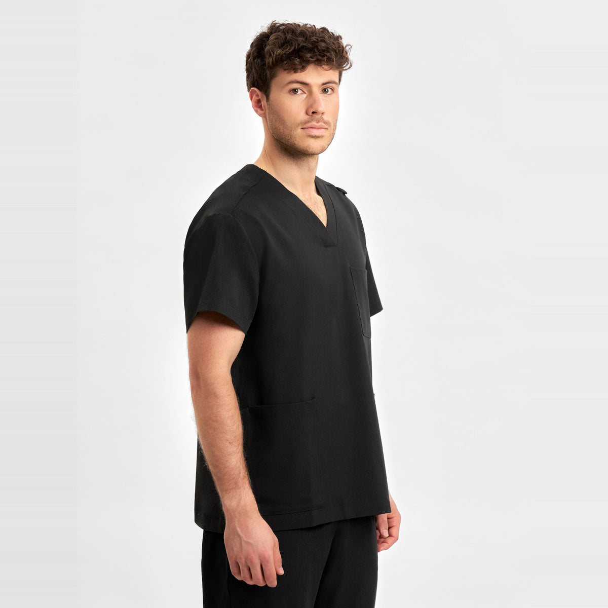 Inaura Pulse Unisex V-Neck Scrub Top CU544US in Black, worn by model, view 3