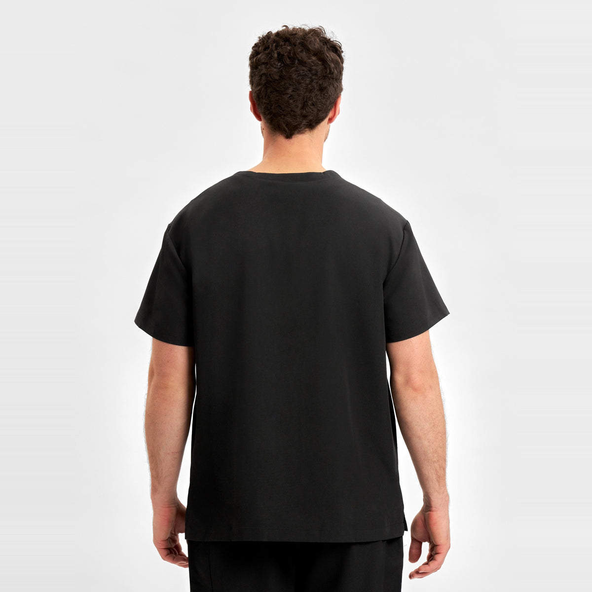 Inaura Pulse Unisex V-Neck Scrub Top CU544US in Black, worn by model, view 4