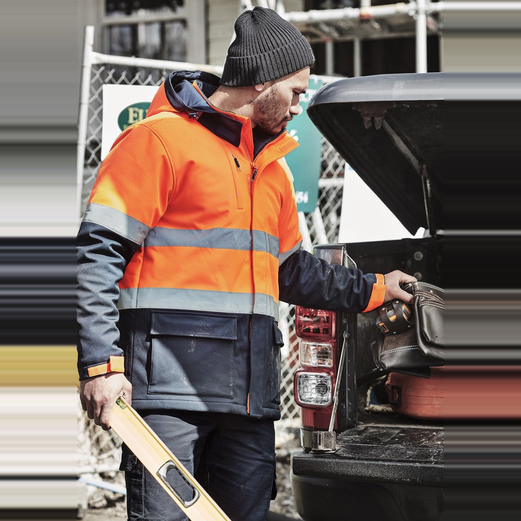 Syzmik Unisex Hi Vis Antarctic Softshell Jacket ZJ553 in Orange/Navy, worn by model, view 2