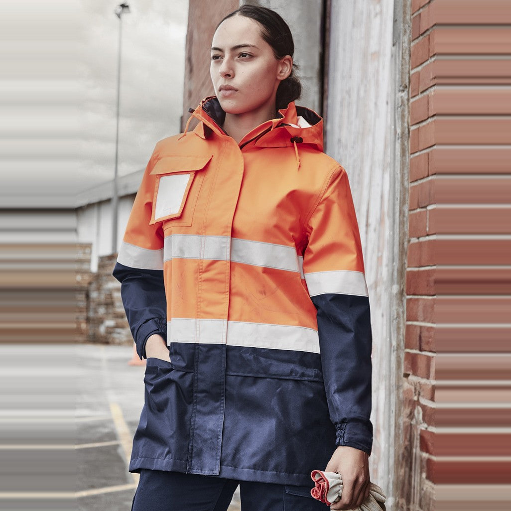 Syzmik Womens Hi Vis Ultralite Waterproof Jacket ZJ757 in Orange/Navy, worn by model