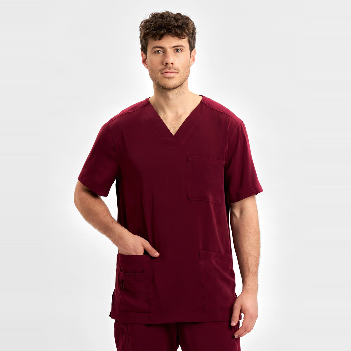 Inaura Avery Mens V-Neck Scrub Top CST945MS in Burgundy, worn by model