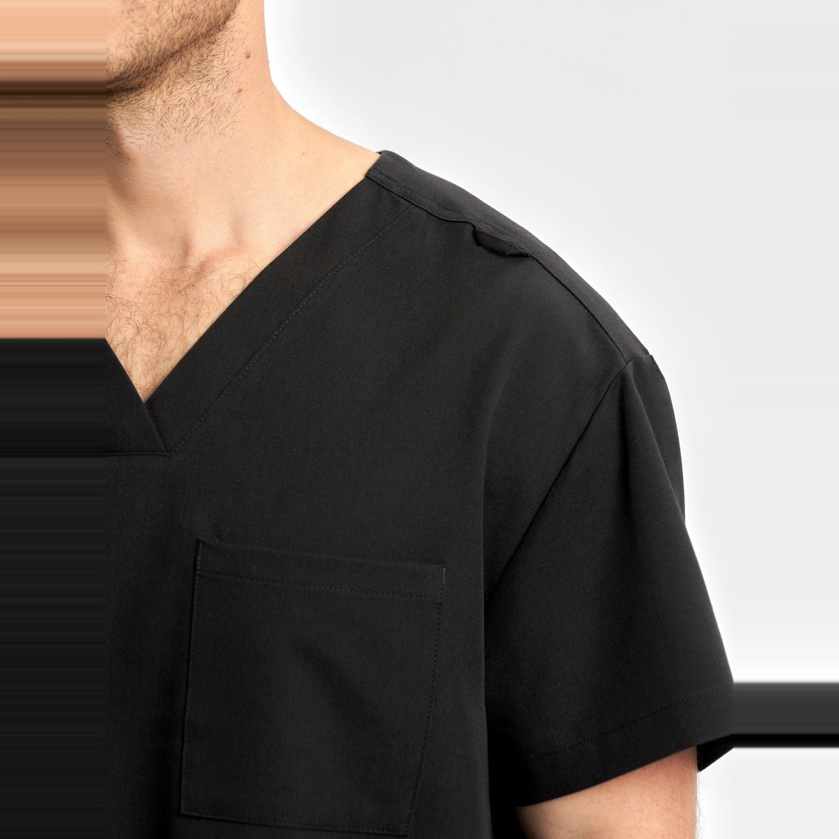 Inaura Pulse Unisex V-Neck Scrub Top CU544US in Black, worn by model, view 5