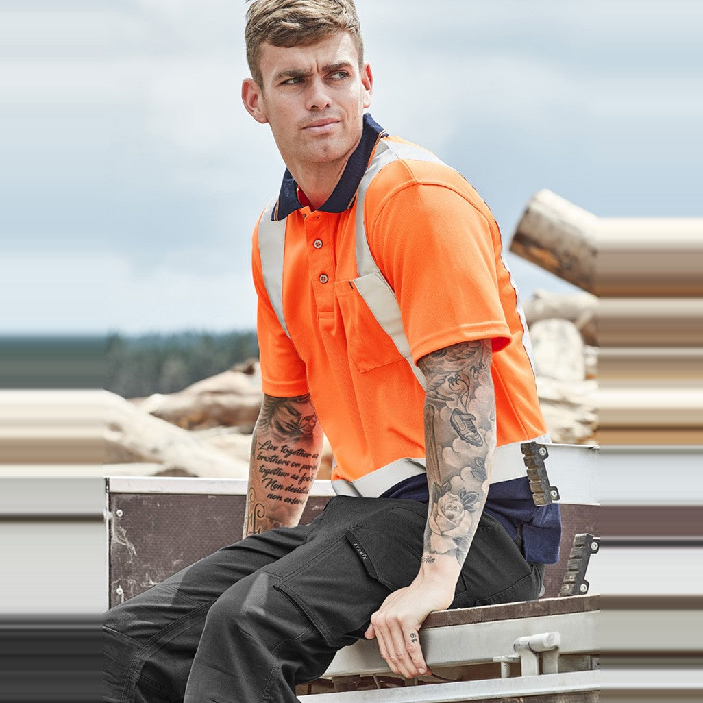 Syzmik Mens Hi Vis Spliced Short Sleeve Polo - Shoulder Taped ZH233 in Orange/Navy, worn by model