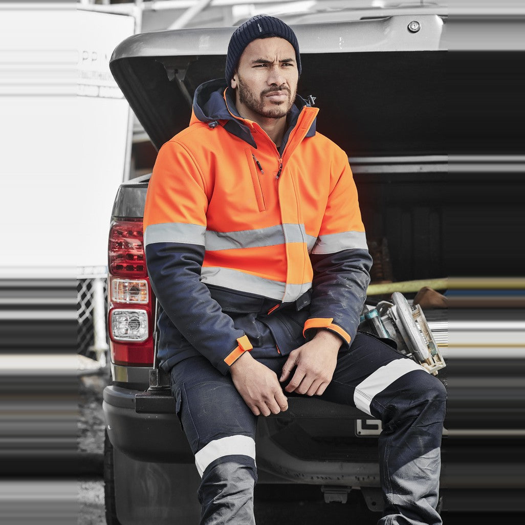 Syzmik Unisex Hi Vis Antarctic Softshell Jacket ZJ553 in Orange/Navy, worn by model