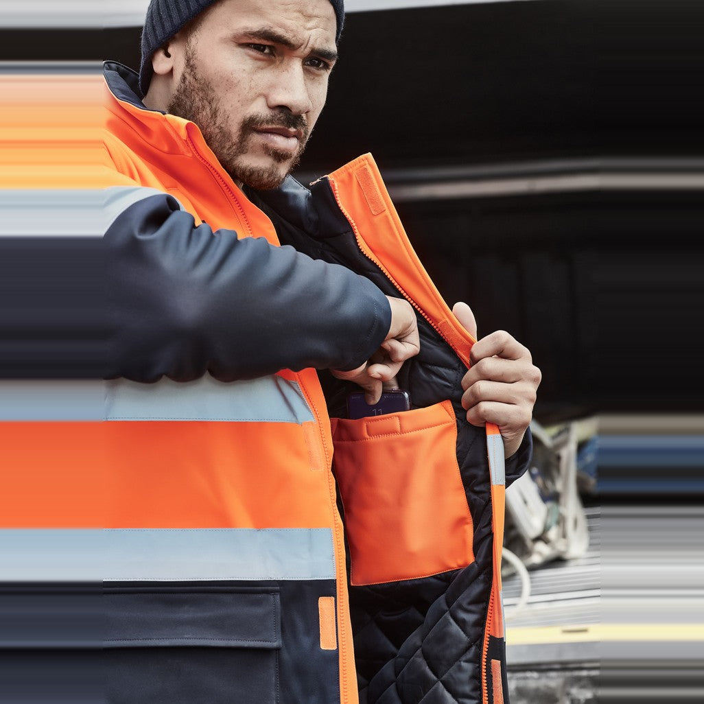 Syzmik Unisex Hi Vis Antarctic Softshell Jacket ZJ553 in Orange/Navy, worn by model, view 3