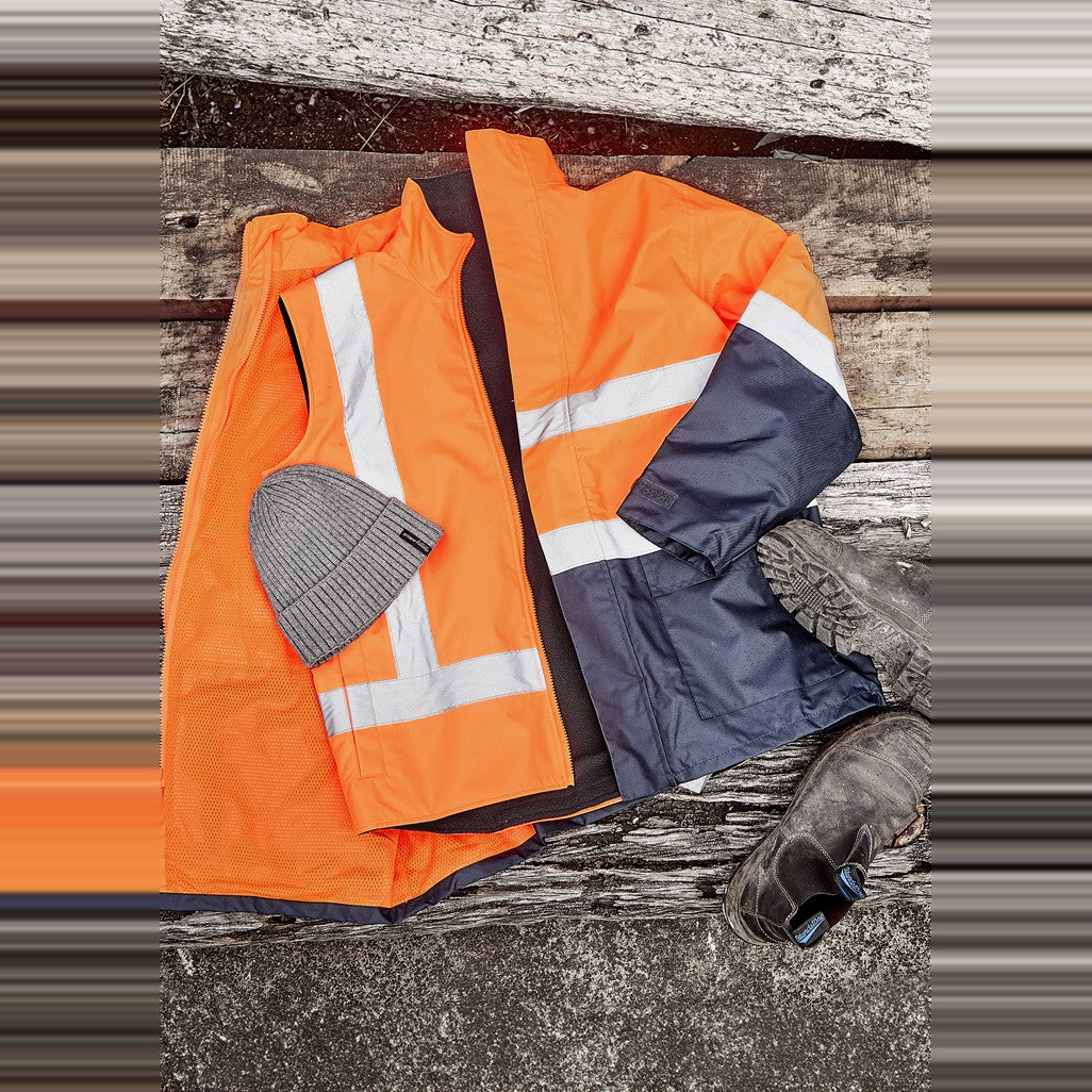 Syzmik Unisex Hi Vis Waterproof Reversible Vest ZV228 in Orange, worn by model